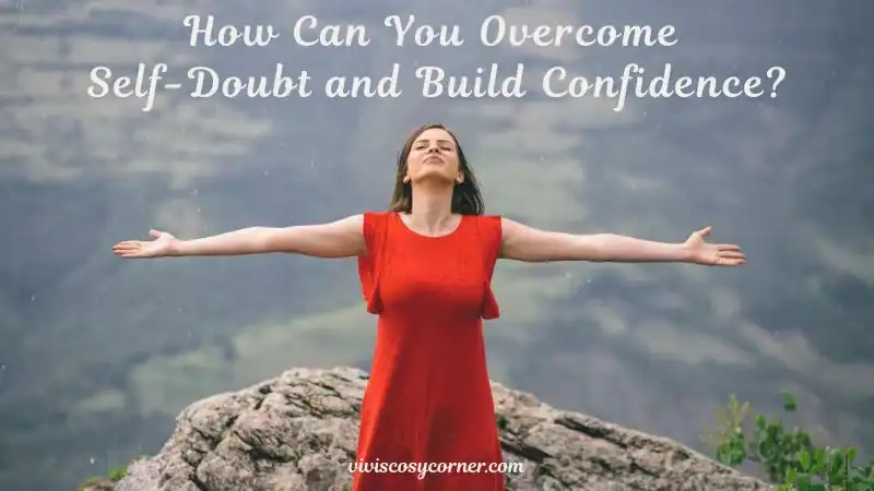 Woman in a red dress stands on a rocky cliff with arms outstretched, a motivational heading above reads, 'How Can You Overcome Self-Doubt and Build Confidence?'