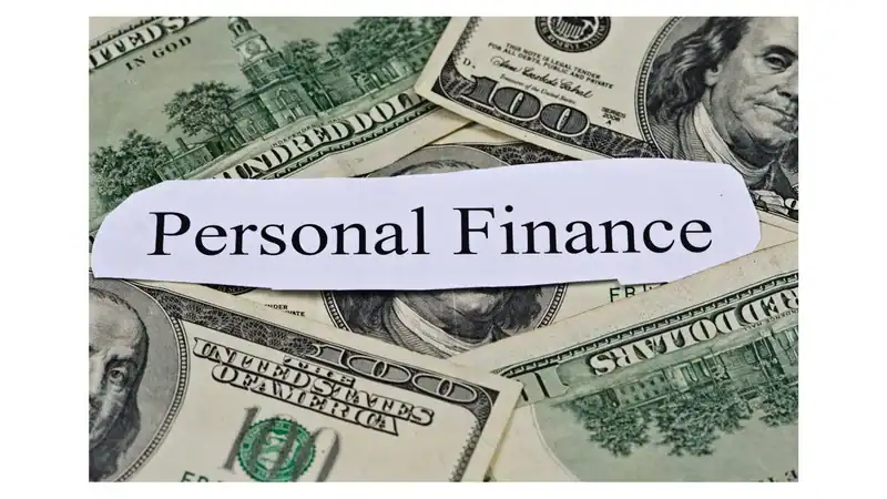 US dollar bills as a background with a torn white label reading 'Personal Finance' laid over them, conveying finance concept