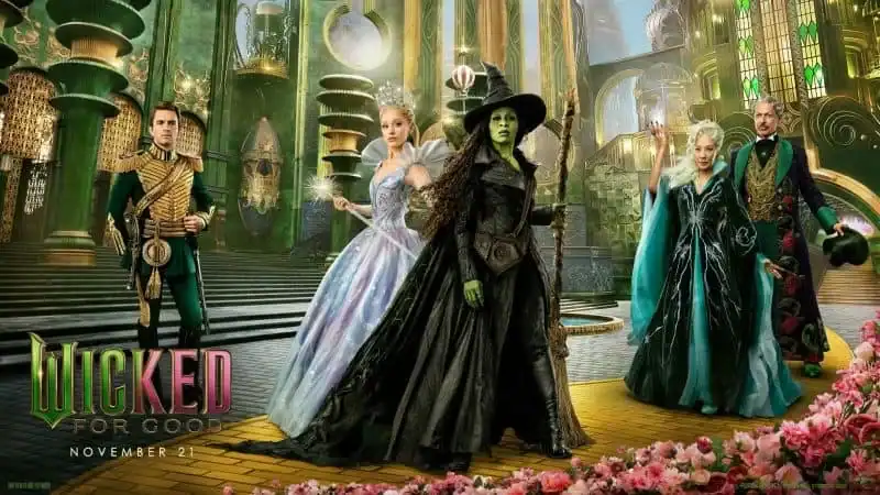 Promotional poster for Wicked for Good: a magical emerald-hued stage with costumed characters, including a green-faced witch, posing on a grand staircase.